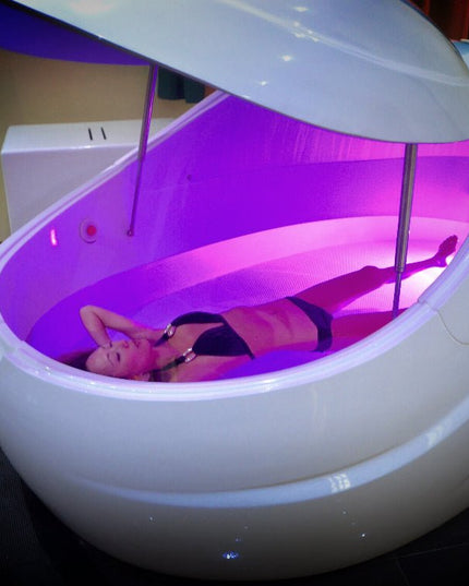 DreamPod V2 Float Pod open with purple lighting and girl floating