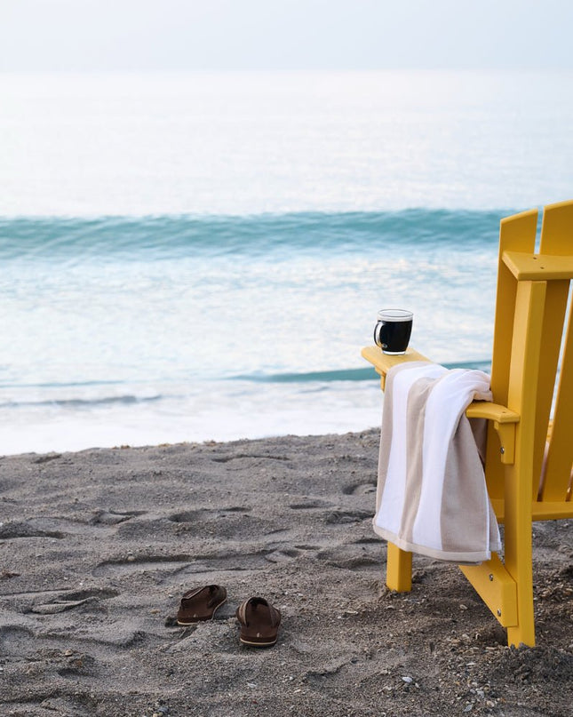 Royal Adirondack chair, yellow, looking over the ocean.